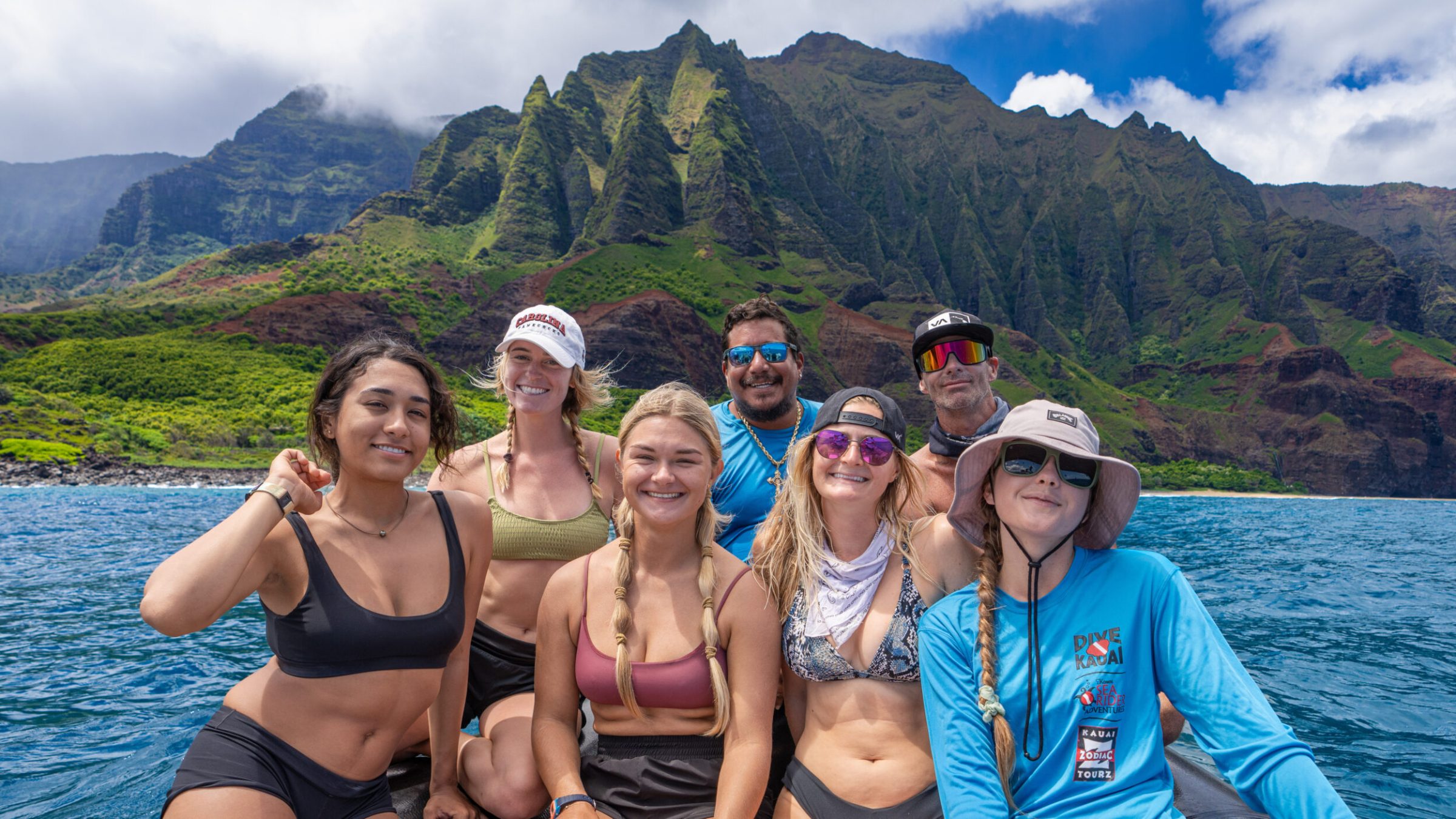 a group of people posing in front of a body of water
