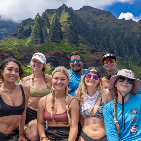 a group of people posing in front of a body of water